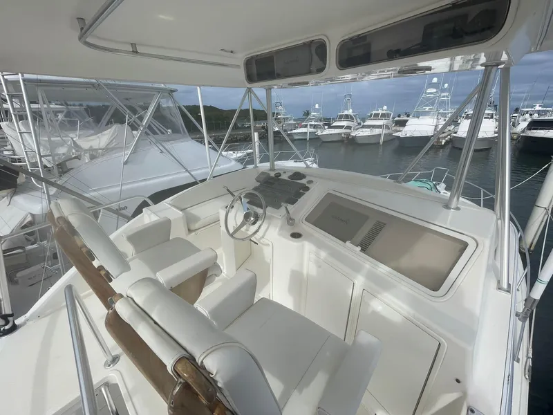 Slide: The Image of 2000 Ocean Yachts Convertible helm with dual seats and marina view. - 14