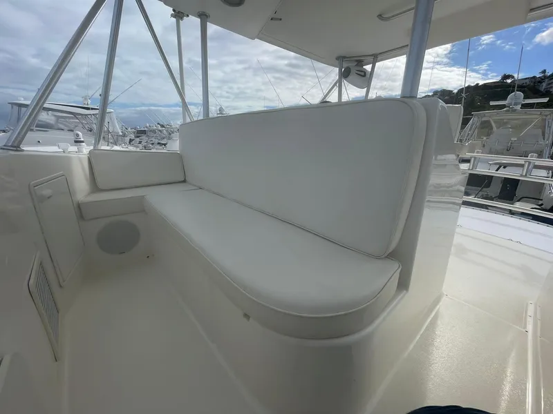 Slide: The Image of 2000 Ocean Yachts Convertible boat with white seating on deck, docked at marina. - 15