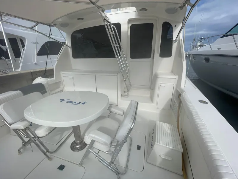 Slide: The Image of 2000 Ocean Yachts Convertible boat with outdoor seating and table on deck. - 2