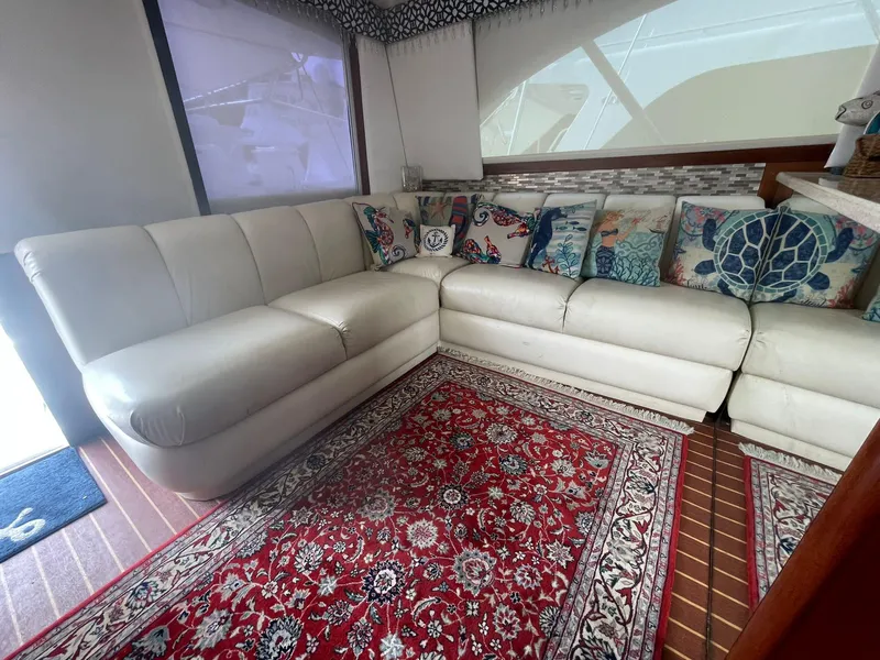 Slide: The Image of Luxurious interior of 2000 Ocean Yachts Convertible with white leather seating and vibrant rug. - 5