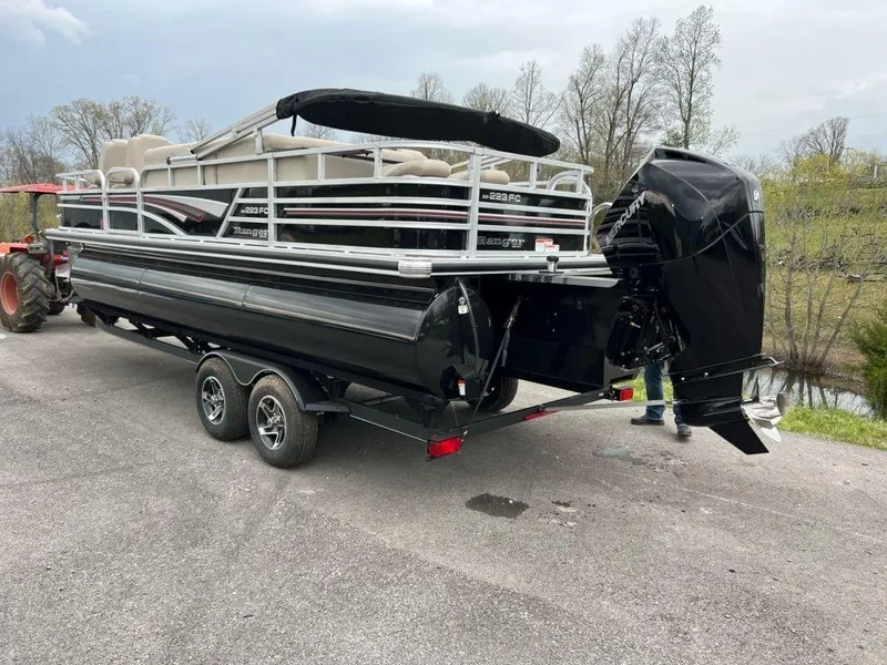 Slide: The Image of 2023 Ranger 223FC pontoon boat on a trailer with an outboard motor. - 14