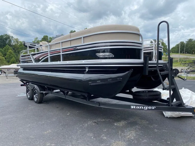 Slide: The Image of 2023 Ranger 223FC pontoon boat on a trailer under cloudy skies. - 16