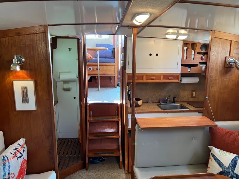 Slide: The Image of Interior of a 1974 Fisher 37 boat with wooden cabinetry and compact kitchen area. - 3
