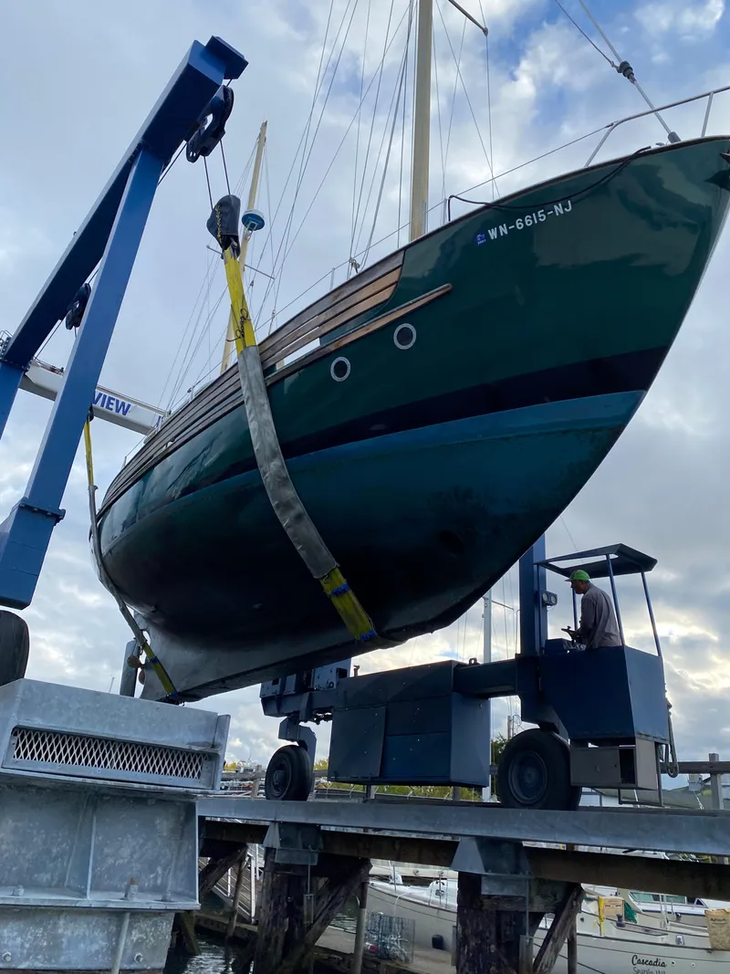 Slide: The Image of 1974 Fisher 37 sailboat being lifted by a crane at a marina. - 5