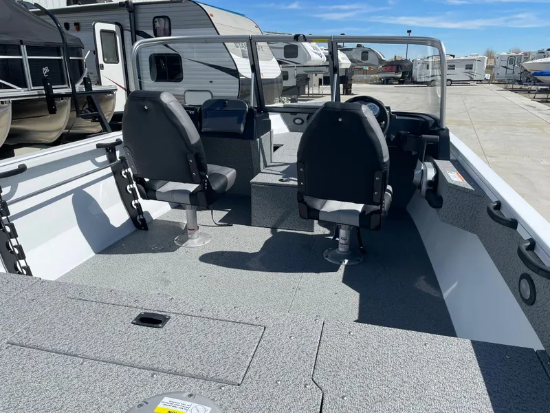 Slide: The Image of 2022 Crestliner 1700 Vision boat interior with two seats, docked near RVs. - 11