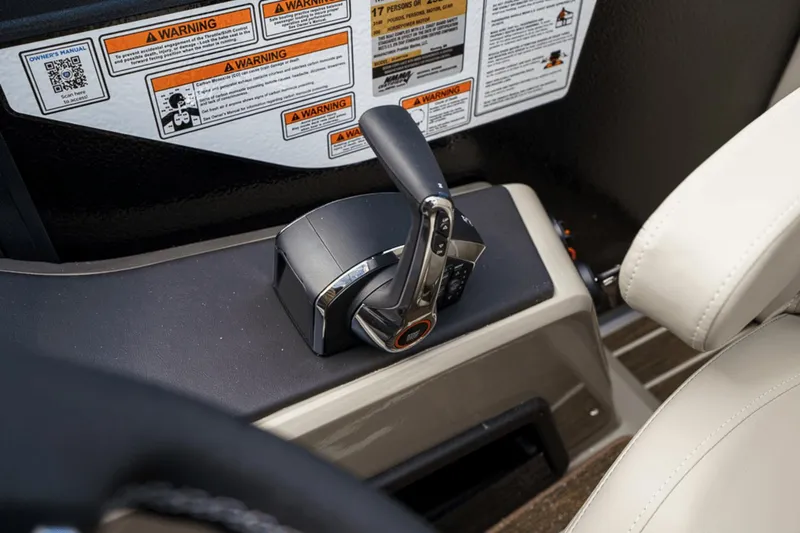 Slide: The Image of Throttle control and warning labels on 2023 Premier 230 Solaris boat dashboard. - 23