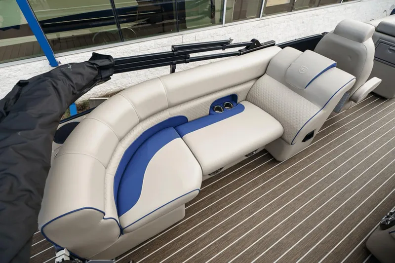 Slide: The Image of 2023 Premier 230 Solaris boat interior with beige and blue seating, cup holders, and striped flooring. - 26