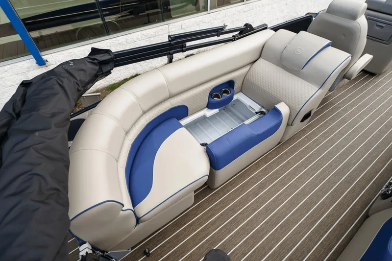 Slide: The Image of 2023 Premier 230 Solaris boat interior with beige and blue seating, open storage compartment. - 27