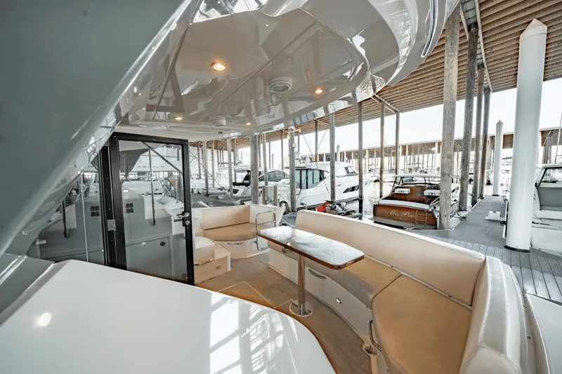 Slide: The Image of 2017 Carver 52 Command Bridge yacht interior with seating and table in marina setting. - 14