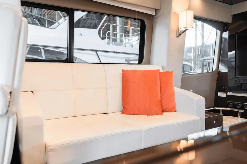 Slide: The Image of Luxurious interior of 2017 Carver 52 Command Bridge with white sofa and orange cushions. - 25