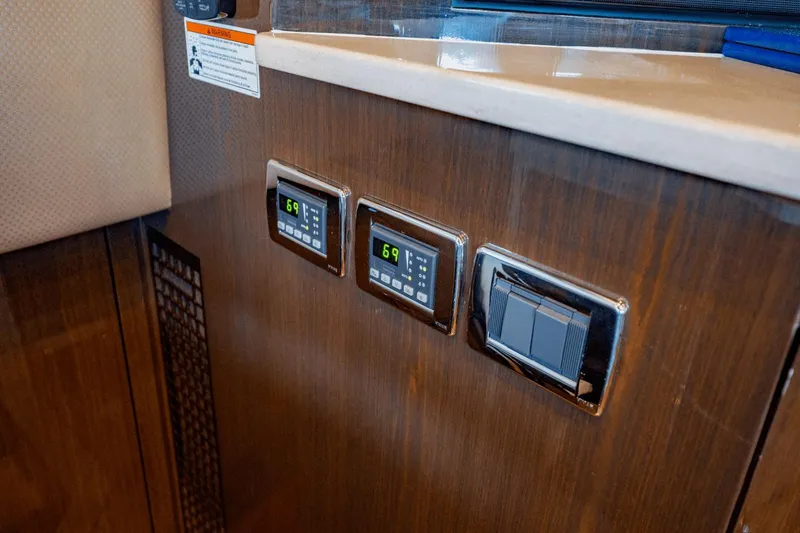 Slide: The Image of Control panel on 2017 Carver 52 Command Bridge yacht interior, featuring digital displays and switches. - 42