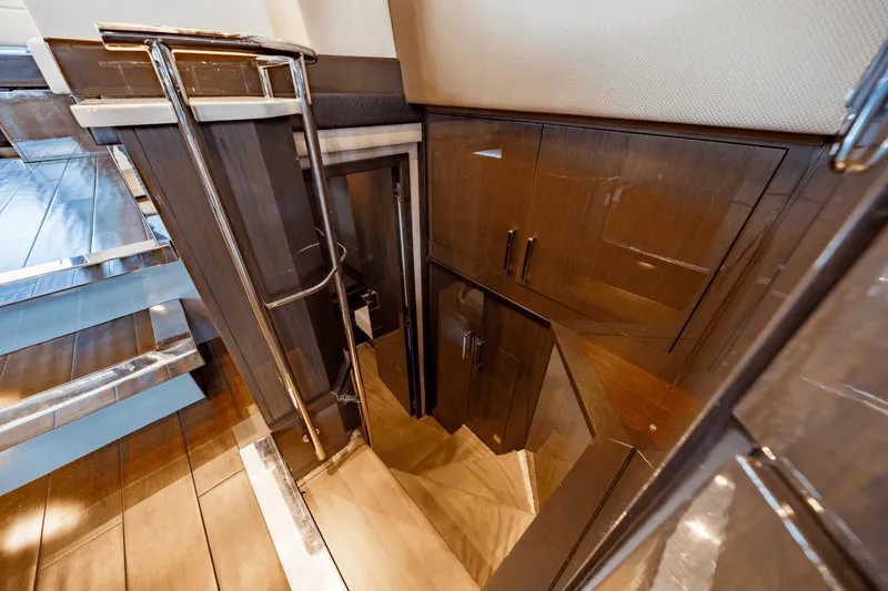 Slide: The Image of Interior stairs of 2017 Carver 52 Command Bridge yacht, featuring sleek wood finish. - 43