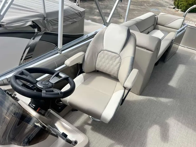 Slide: The Image of 2023 Avalon 2380 Venture Quad Lounger boat interior with steering wheel and plush seating. - 8
