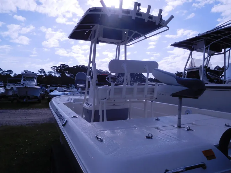Slide: The Image of 2015 Skeeter SX 240 boat with T-top and seating, docked outdoors. - 2
