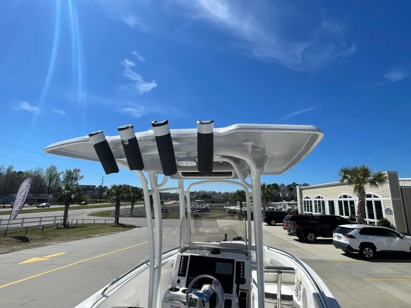 Slide: The Image of 2024 Robalo R222 Center Console boat with T-top under clear blue sky. - 12