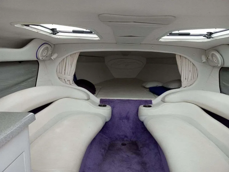 Slide: The Image of Interior of a 1999 Baja 33 Outlaw boat with plush seating and purple carpet. - 10