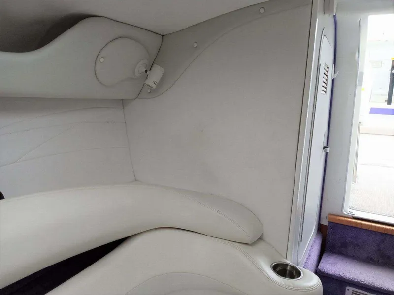 Slide: The Image of 1999 Baja 33 Outlaw interior cabin with white seating and modern design. - 12