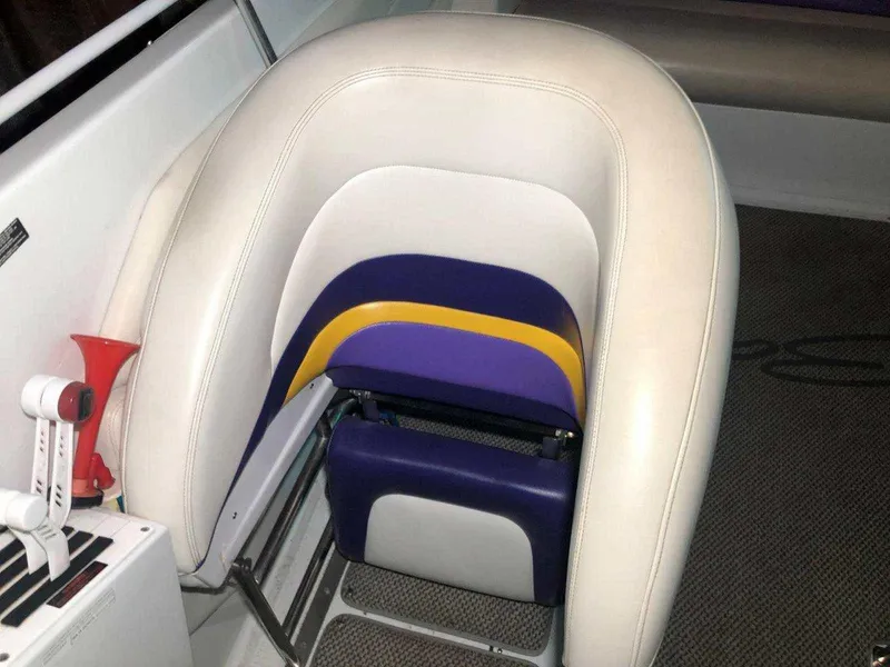 Slide: The Image of 1999 Baja 33 Outlaw boat seat with white, purple, and yellow upholstery. - 23