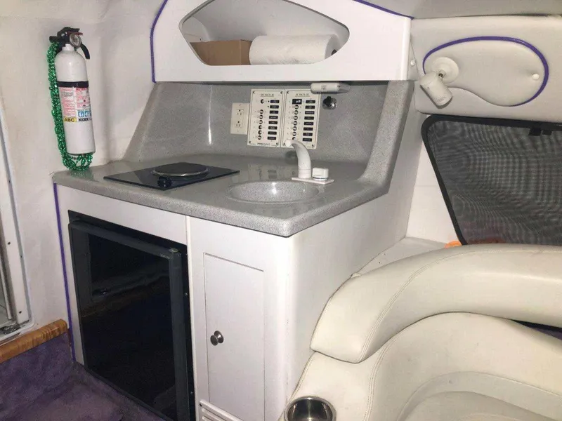 Slide: The Image of 1999 Baja 33 Outlaw cabin with kitchenette, featuring sink, stove, and fire extinguisher. - 25