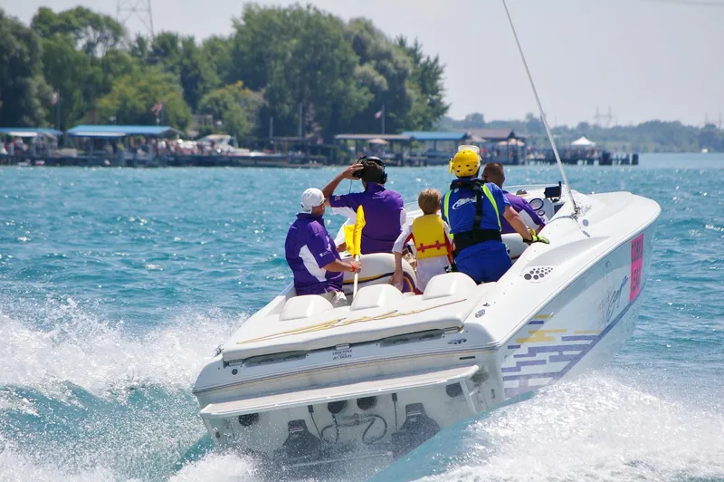 Slide: The Image of 1999 Baja 33 Outlaw speedboat with passengers cruising on a sunny day. - 3