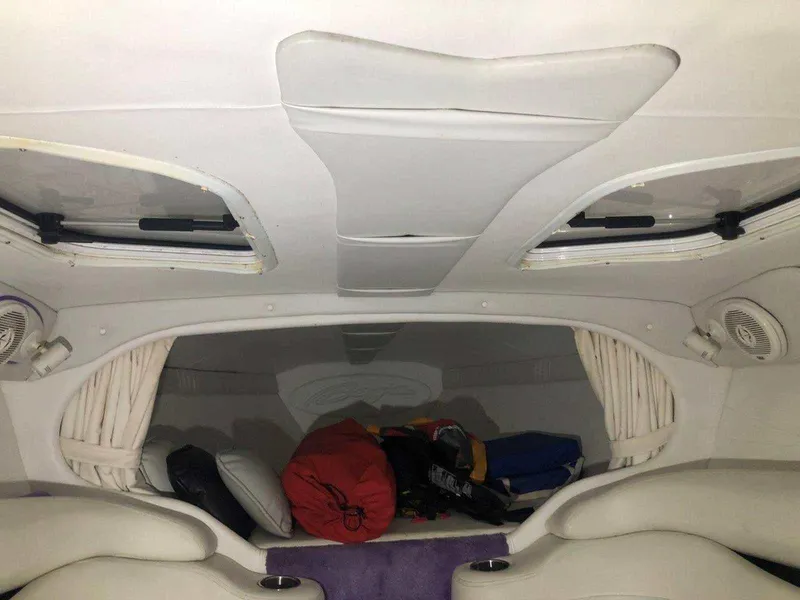 Slide: The Image of Interior cabin of a 1999 Baja 33 Outlaw boat with white seating and storage. - 31