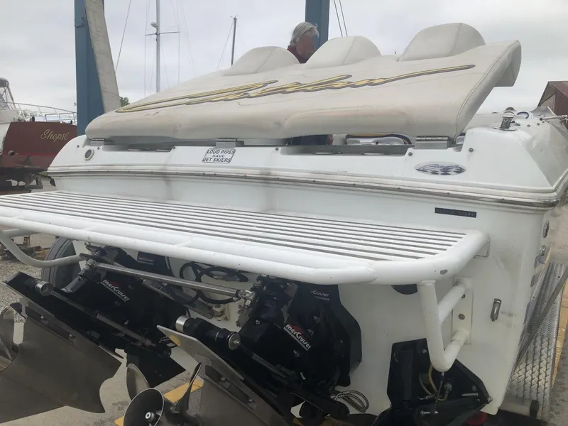 Slide: The Image of 1999 Baja 33 Outlaw boat with powerful engines and sleek design at a marina. - 38