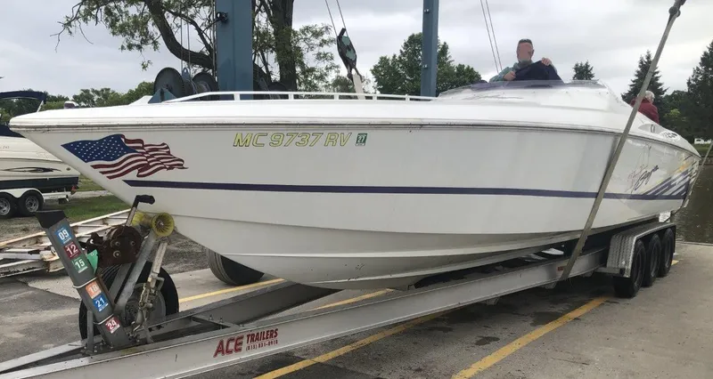 Slide: The Image of 1999 Baja 33 Outlaw boat on trailer, featuring American flag decal. - 41