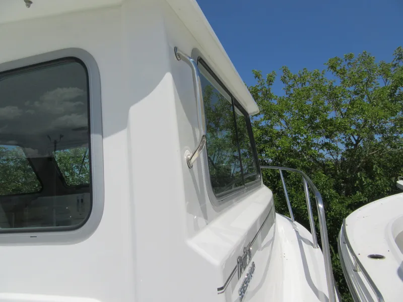 Slide: The Image of 2023 Parker 2520 XLD Sport Cabin boat exterior with windows and railing. - 15
