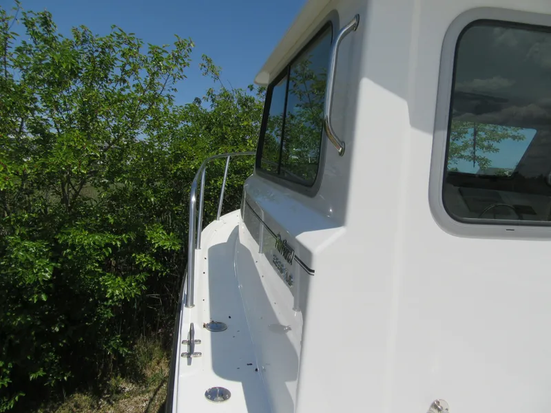 Slide: The Image of 2023 Parker 2520 XLD Sport Cabin boat side view with windows and railing. - 16