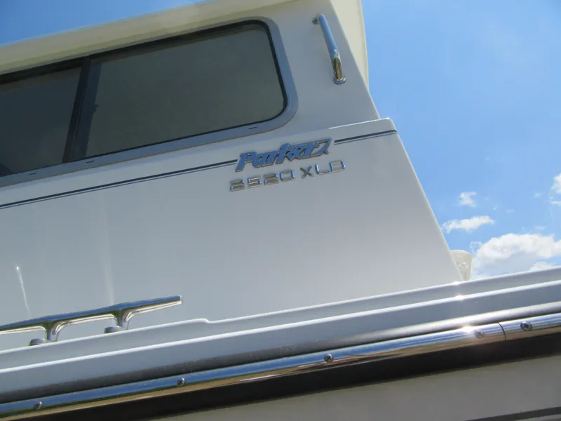 Slide: The Image of 2023 Parker 2520 XLD Sport Cabin boat exterior under blue sky. - 17