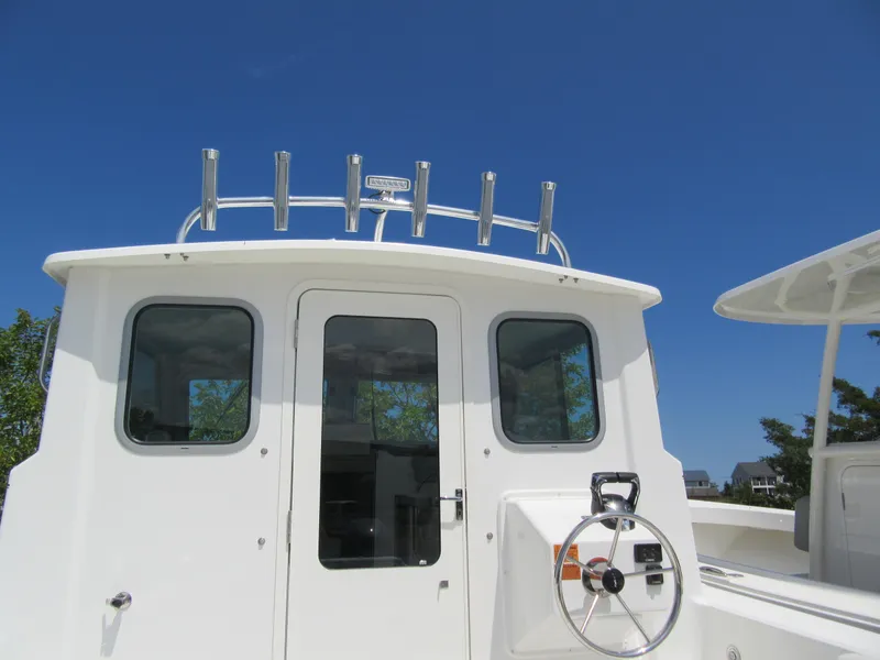 Slide: The Image of 2023 Parker 2520 XLD Sport Cabin boat with white exterior and blue sky background. - 7