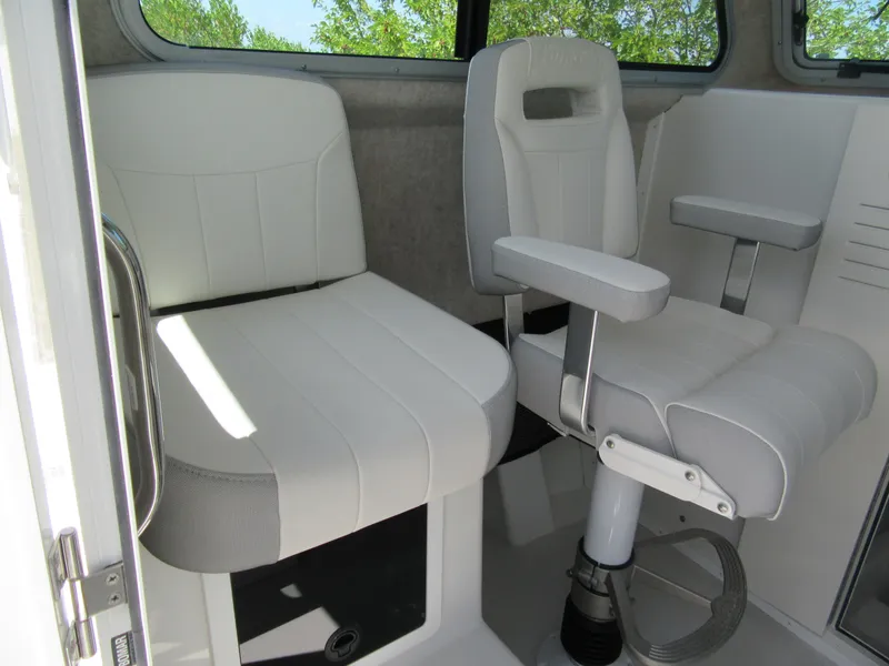Slide: The Image of 2023 Parker 2520 XLD Sport Cabin interior seating with white cushioned chairs. - 8