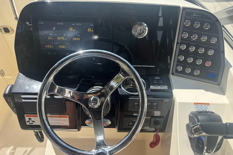Slide: The Image of 2022 Scout 255 Dorado boat dashboard with steering wheel and control panel. - 18