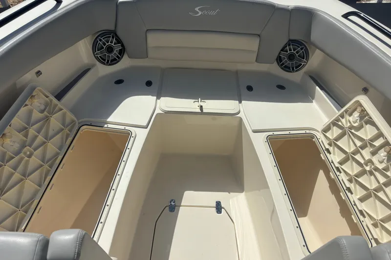 Slide: The Image of 2022 Scout 255 Dorado boat interior with open storage compartments and speakers. - 22