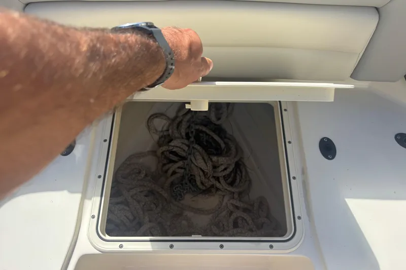 Slide: The Image of Opening storage compartment on 2022 Scout 255 Dorado boat, revealing coiled ropes inside. - 23