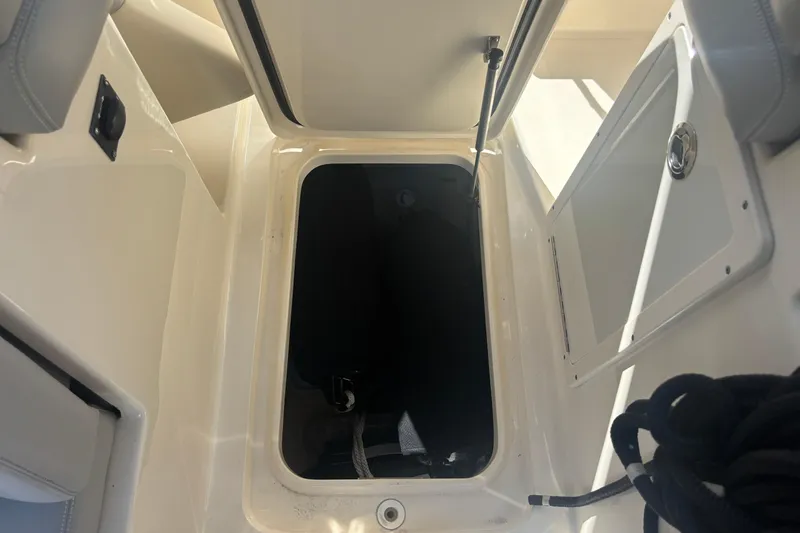 Slide: The Image of 2022 Scout 255 Dorado boat storage compartment with open hatch and visible interior. - 27