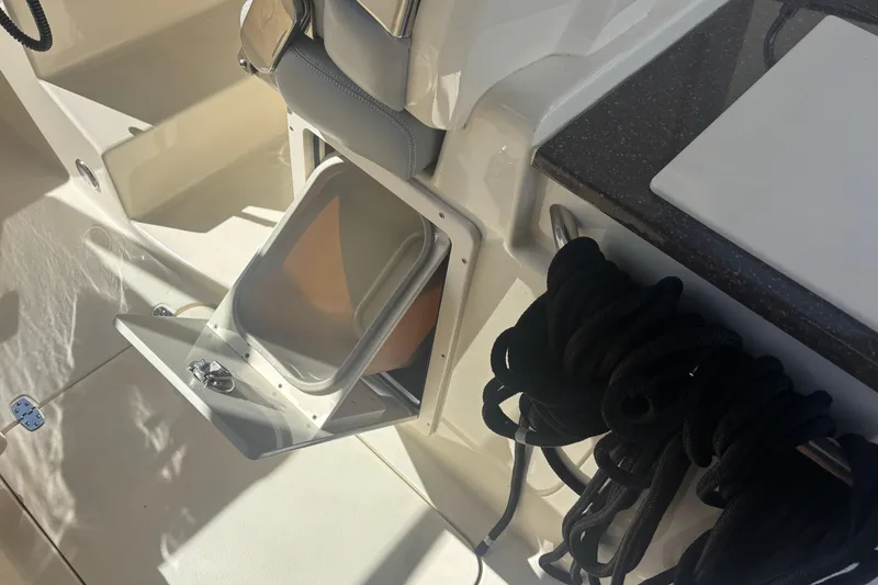 Slide: The Image of 2022 Scout 255 Dorado boat interior with storage compartment and coiled rope. - 28