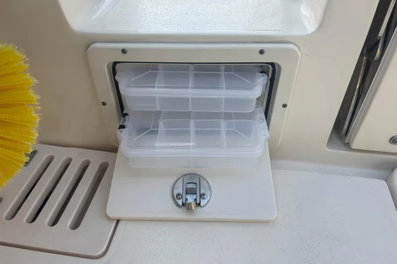 Slide: The Image of Storage compartment with clear containers on a 2022 Scout 255 Dorado boat. - 34