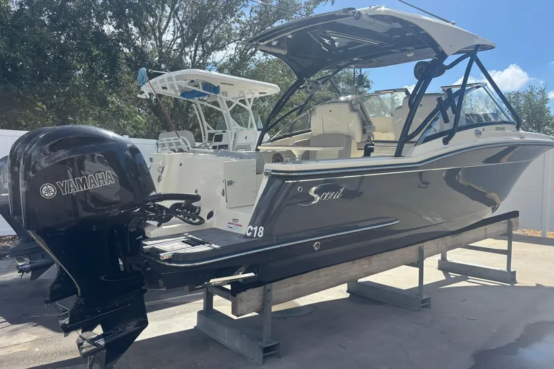 Slide: The Image of 2022 Scout 255 Dorado boat with Yamaha engine, displayed on a stand outdoors. - 4