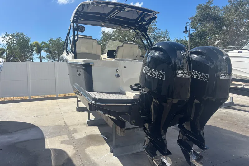 Slide: The Image of 2022 Scout 255 Dorado boat with dual Yamaha 200 engines, parked outdoors. - 5