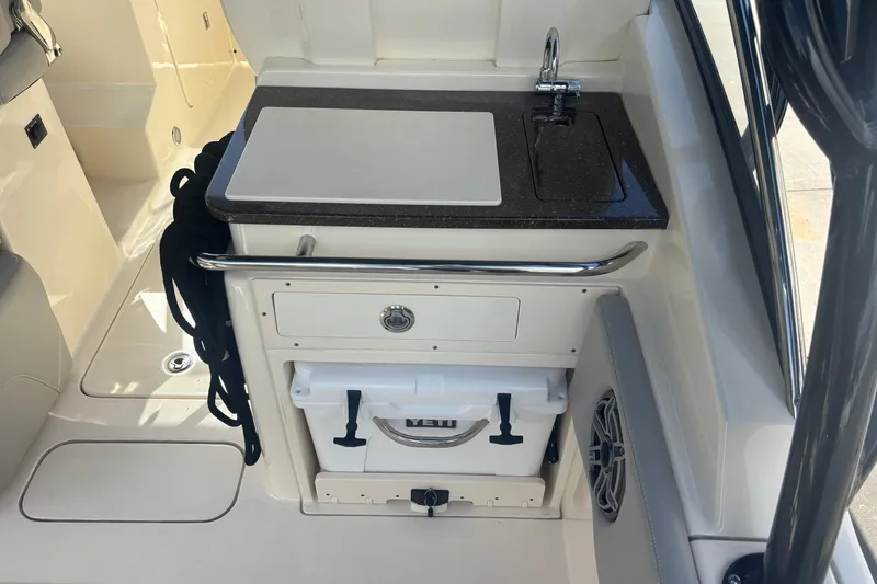 Slide: The Image of 2022 Scout 255 Dorado boat interior with sink, storage, and cooler. - 9