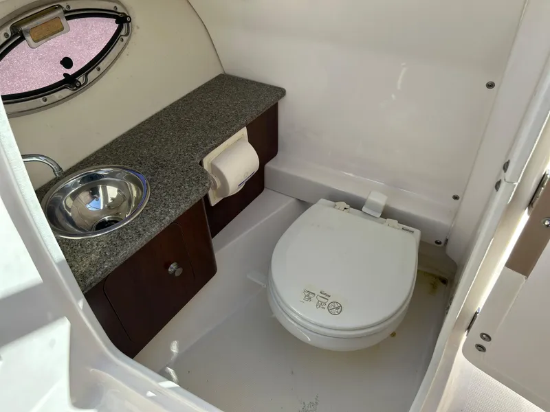 Slide: The Image of 2014 Chaparral Sunesta 244 boat bathroom with sink, toilet, and storage cabinet. - 31