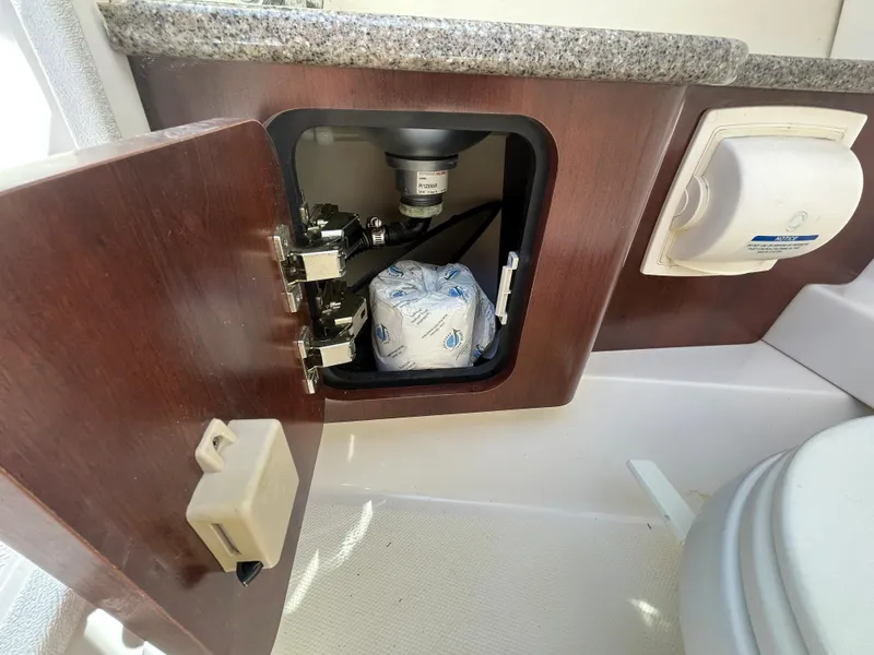 Slide: The Image of 2014 Chaparral Sunesta 244 boat interior storage compartment with toilet paper holder. - 33