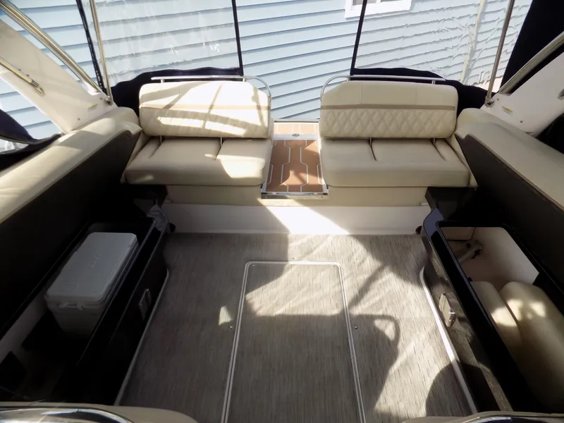 Slide: The Image of 2019 Regal 2800 Bowrider interior with beige seating and carpeted flooring. - 7