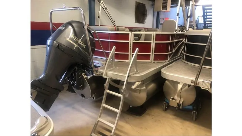 Slide: The Image of 2023 Bennington 24SXL pontoon boat with Yamaha outboard motor in storage. - 1
