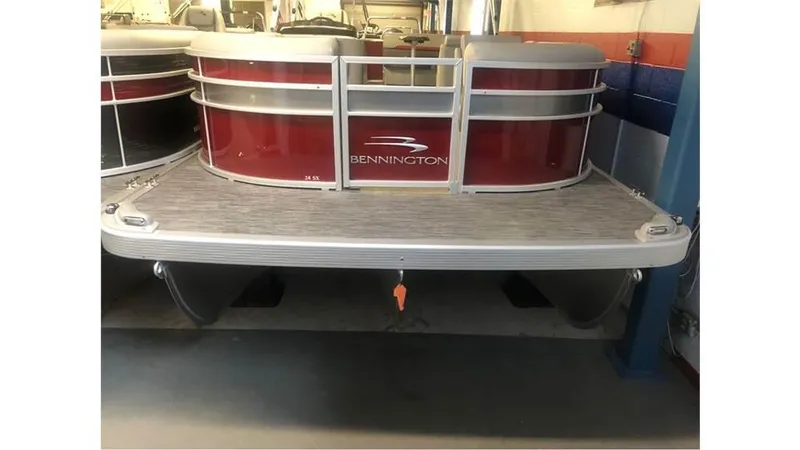 Slide: The Image of 2023 Bennington 24SXL pontoon boat in a showroom. - 2