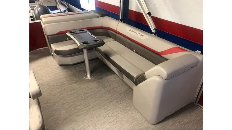 Slide: The Image of 2023 Bennington 24SXL pontoon boat interior with plush seating and table. - 7