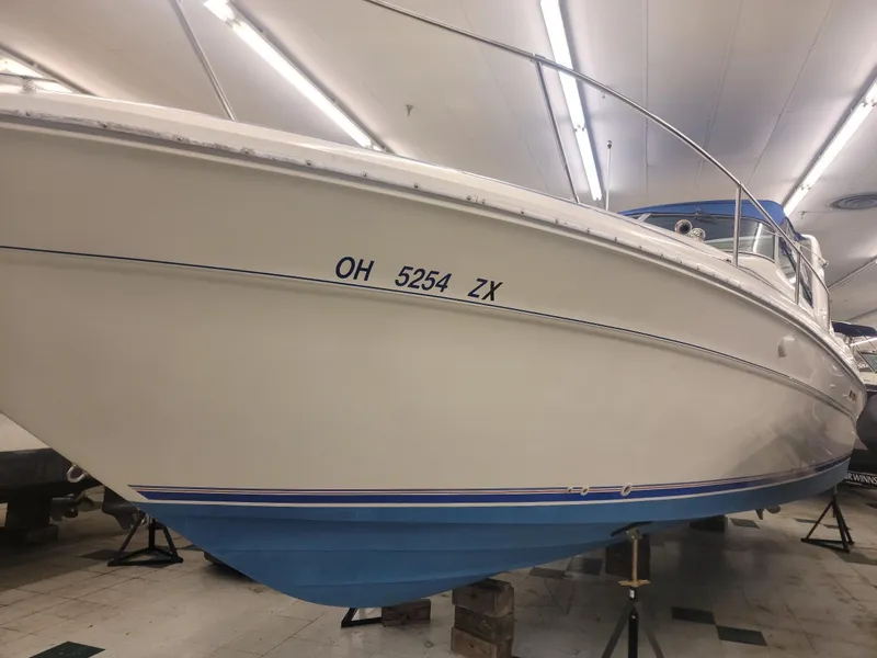 Slide: The Image of 1992 Sea Ray 330 Sundancer boat on stands in indoor storage. - 12