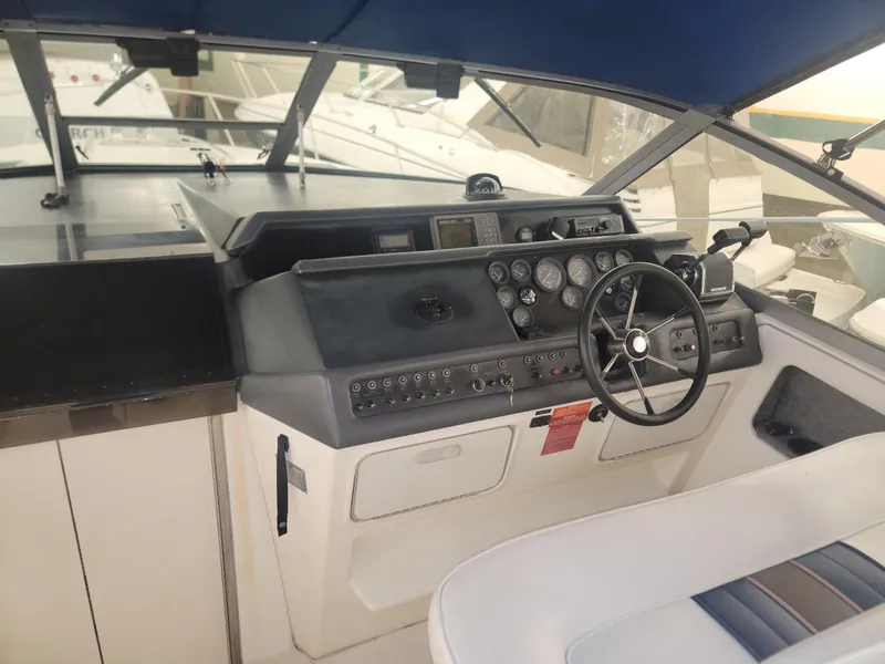Slide: The Image of 1992 Sea Ray 330 Sundancer helm with steering wheel, gauges, and controls. - 32