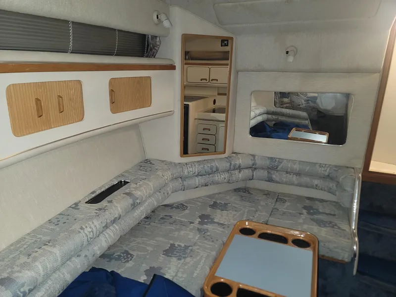 Slide: The Image of Interior of 1992 Sea Ray 330 Sundancer with cushioned seating, storage cabinets, and a mirror. - 35